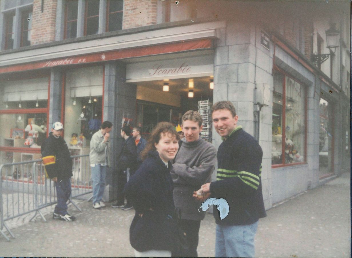 Three members outside a shop on a trip abroad