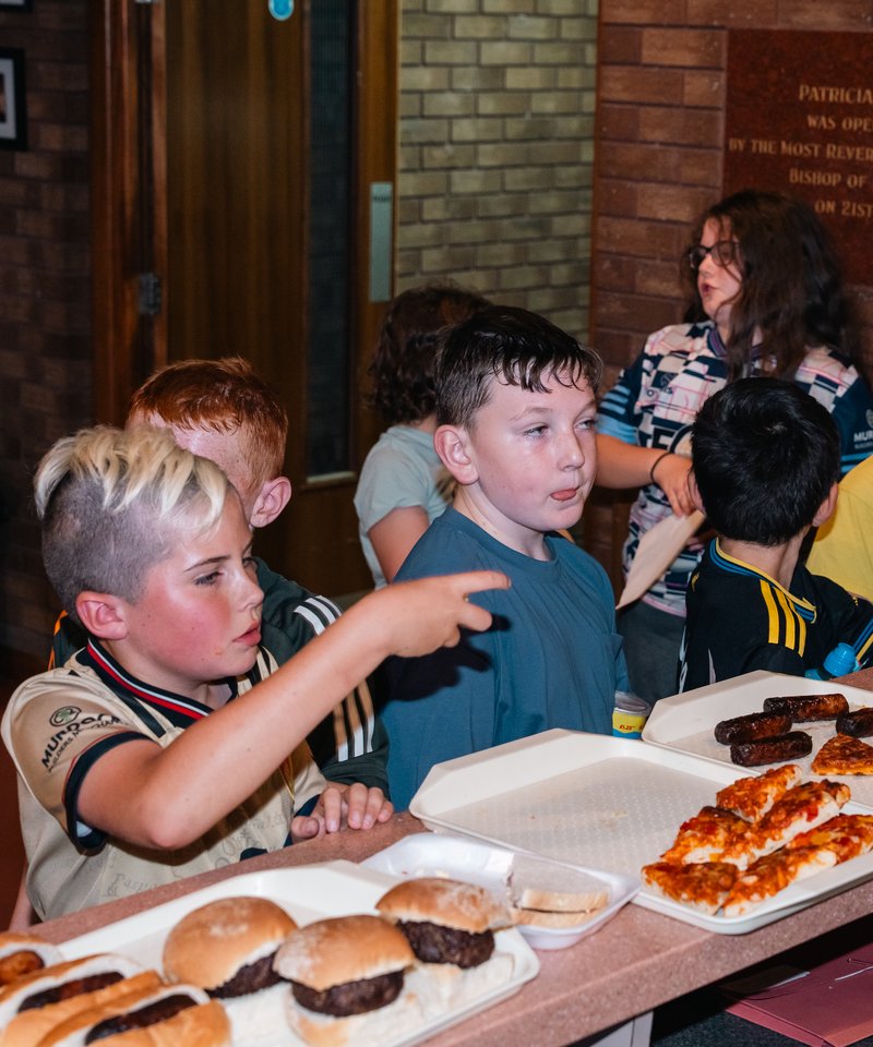 Members at the counter as burgers and pizza come out at a club night